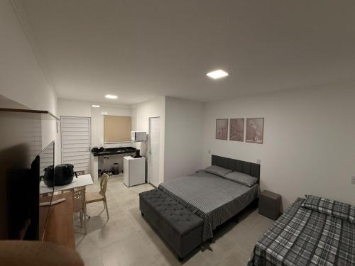 a bedroom with a bed and a couch and a desk at Flats Privativos MaragoJulios in Maragogi