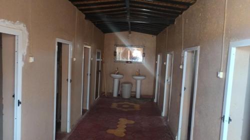 a hallway with two sinks and two toilets in a room at Authentic Sahara with Locals in Tagounite