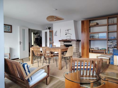 Beach Villa في Saint-Germain-sur-Ay: غرفة معيشة بها طاولة طعام وكراسي