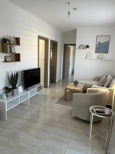 a living room with a couch and a television at ArtStay-Apartment in Orestiada