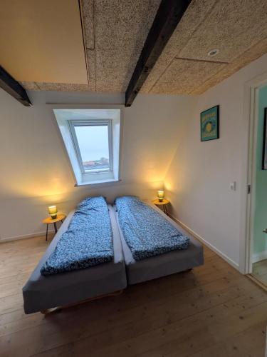 a bedroom with two beds in a room with a window at Hus 5 personer in Hjørring
