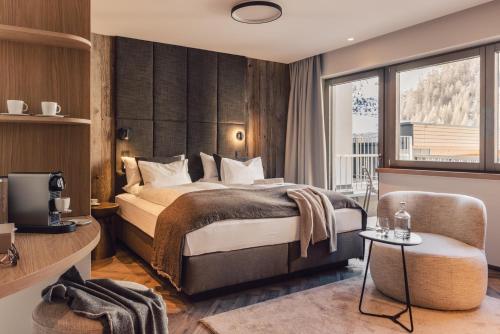 a hotel room with a bed and a window at Das Liebener 4 Sterne Superior - ADULTS ONLY! in Obergurgl