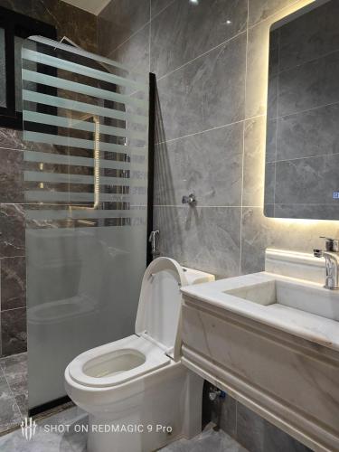 a bathroom with a white toilet and a sink at شقة كامله ومطبخ وسط جدة in Jeddah