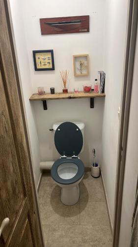 a bathroom with a toilet with a blue seat at Location 6 personnes patrimonio in Patrimonio