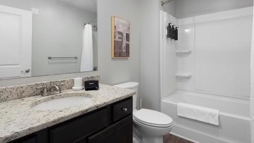 a white bathroom with a sink and a toilet at Landing Amazing Studio Gym in Spartanburg