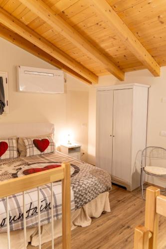 a bedroom with a bed and a wooden ceiling at Il borghetto di Torno in Torno