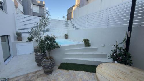 a courtyard with potted plants and a swimming pool at Myronos suite with jacuzzi in Piraeus