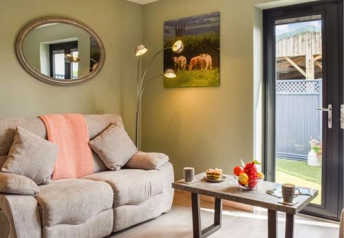 a living room with a couch and a table at Pentarow Barn in Falmouth
