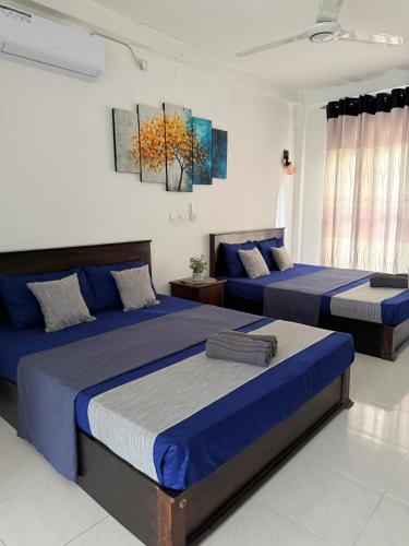 two beds in a bedroom with blue and white at NO 10 Kandy by Kepler & Earth in Kandy