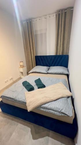 a large bed with a blue headboard in a bedroom at Apartament Tarasy Wenecji 2 in Gniezno