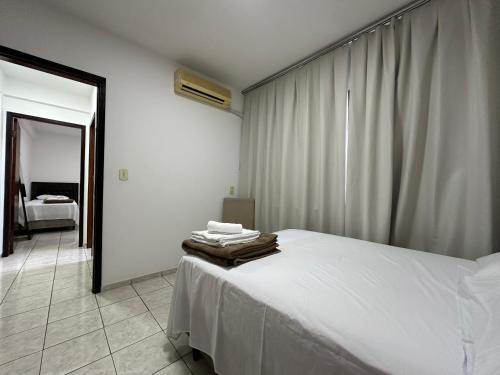 a bedroom with a bed with towels on it at Apartamentos Nadai 201 in Foz do Iguaçu