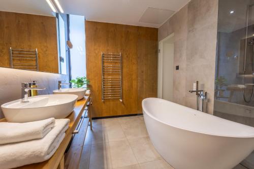a bathroom with two sinks and a large tub at Lajvér Borbirtok in Szálka