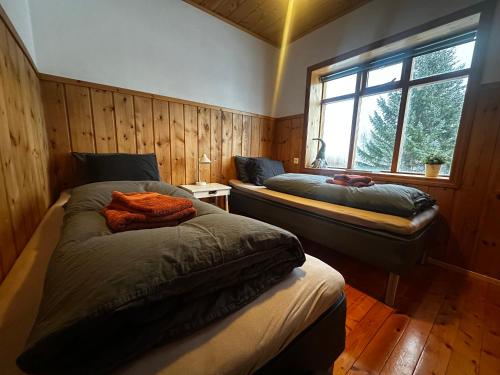 a bedroom with two beds and a window at Hengifosslodge Skáldahús in Egilsstaðir