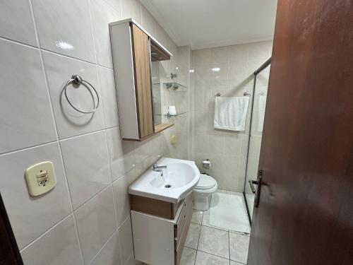 a bathroom with a sink and a toilet and a shower at Apartamentos Nadai 201 in Foz do Iguaçu