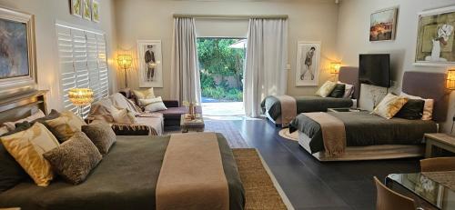 a living room with two beds and a couch at Art and Accommodation Guesthouse in Cape Town