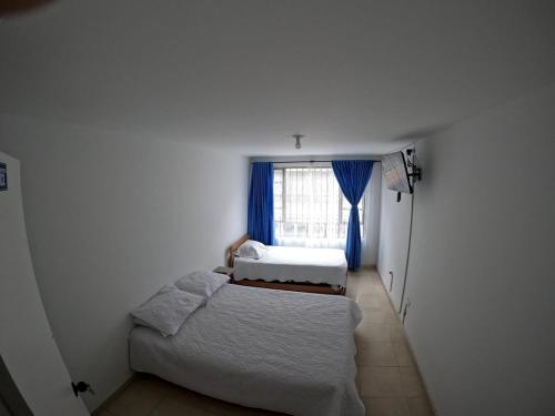 a small bedroom with two beds and a window at Bacata Housing full in Bogotá
