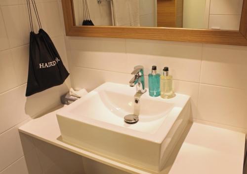 a white sink in a bathroom with a black bag at Spahotel Casino in Savonlinna