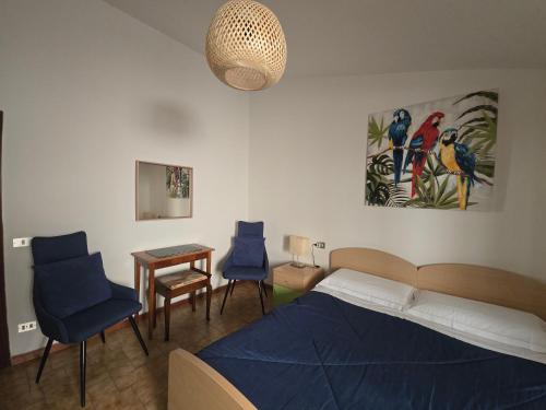 a bedroom with a bed and two blue chairs at La Dimora Di Pienza in Pienza