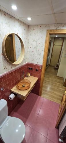 a bathroom with a sink and a mirror and a toilet at Mirador del Torreón in Alcañiz