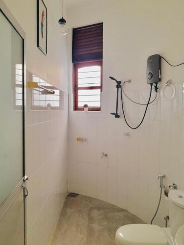 a bathroom with a toilet and a window at Kandy Rainbow Villa in Kandy
