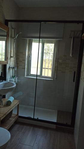 a bathroom with a glass shower and a sink at Villa Antonia in Chipiona