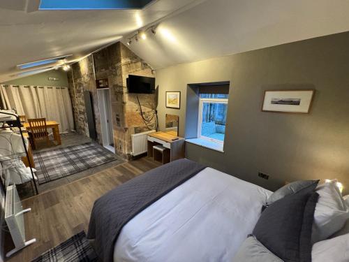 a bedroom with a bed and a room with a window at Crannaig House in Aberfoyle