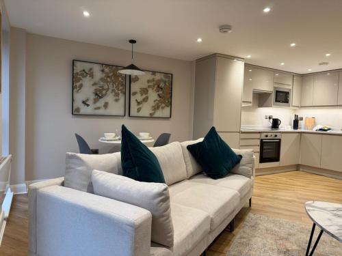 a living room with a couch and a kitchen at Cosy 1 bed Leeds City Centre Apartment in Central Station