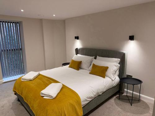 a bedroom with a large bed with yellow sheets and pillows at Cosy 1 bed Leeds City Centre Apartment in Central Station
