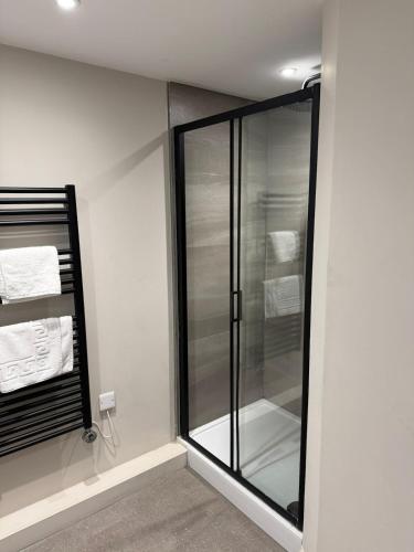 a glass shower in a bathroom with towels at Cosy 1 bed Leeds City Centre Apartment in Central Station