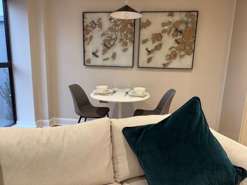 a living room with a couch and a table with chairs at Cosy 1 bed Leeds City Centre Apartment in Central Station