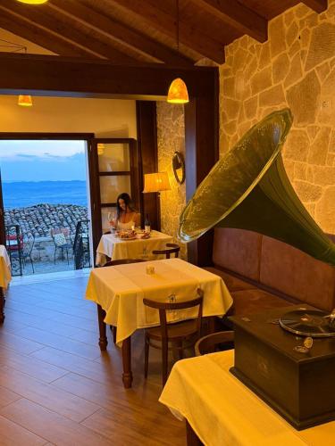 a restaurant with tables and a woman sitting at a table at Kruja Albergo Diffuso , Inside Kruja Castle in Krujë
