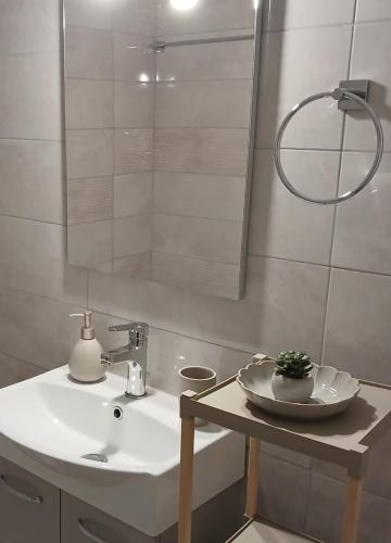 a white bathroom with a sink and a mirror at Lithaia Aura-Trikala in Pýrgos