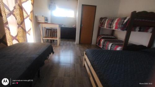 a room with two bunk beds and a table at Lo de Benja in Agote
