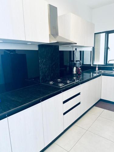a kitchen with white cabinets and black counter tops at Sea esta villa in Mount Lavinia