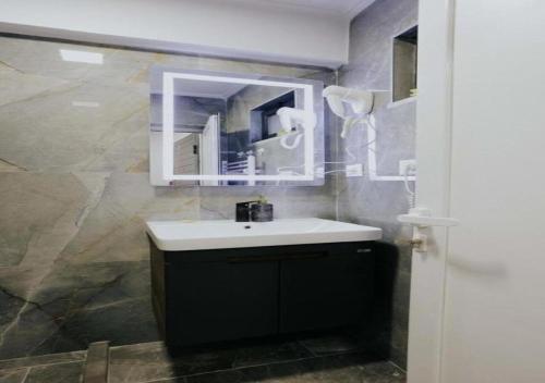 un bagno con lavandino e specchio di Lapi Guest House Korca a Korçë