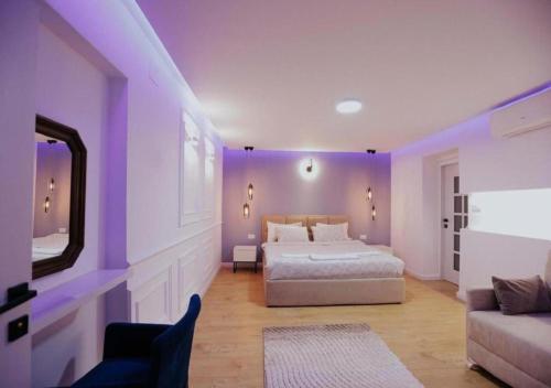 una camera da letto viola con un letto e un divano di Lapi Guest House Korca a Korçë