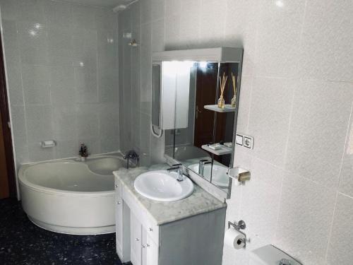 a bathroom with a tub and a sink and a bath tub at Habitaciones Carmen in Rubí