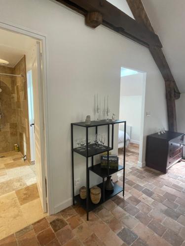 a room with a black shelf with vases on it at Gîte des Templiers in Couches