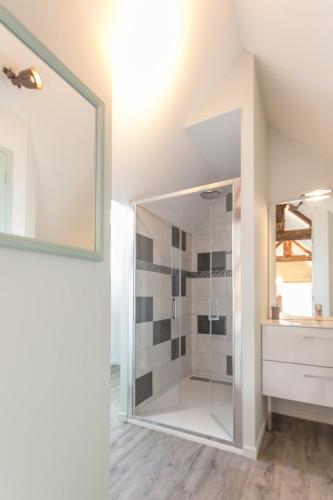 a bathroom with a shower with a glass door at Le Relais des Flâneurs in Thaon