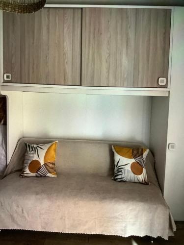 a bed with two pillows sitting under a cabinet at A casa di Giulia in Filettino