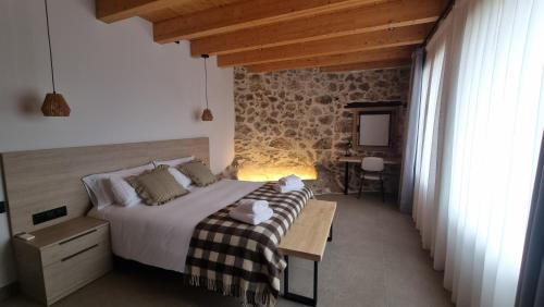 a bedroom with a bed and a stone wall at Cal Rocamartí, Turisme Rural - Montant de Tost, Pirineu in Montant