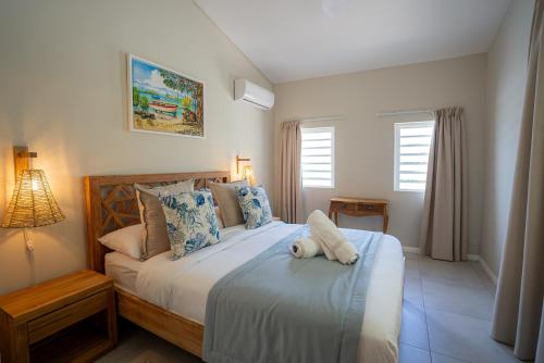 a bedroom with a bed with a stuffed animal on it at Villa Pwani in Baie du Tombeau