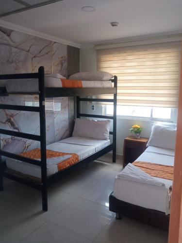 two bunk beds in a room with a window at Hotel Najjez in Villavicencio