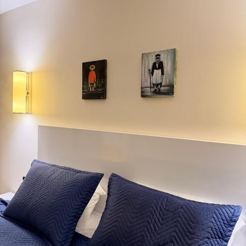 a bedroom with three pictures on the wall and a bed at EVIS LTD apartments Batumi 2 in Angisa