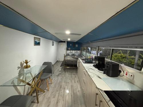 a room with a table and chairs and a couch at Venus Elegant - Getaway Bus in Khlorakas