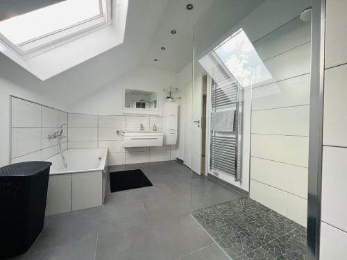 a white bathroom with a tub and a sink at Spacious home in quiet surroundings in Schwanden
