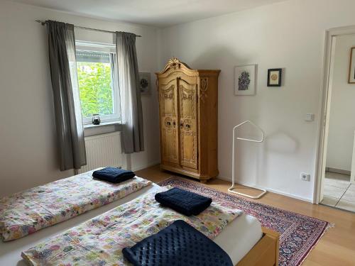 a room with two beds and a chair and a window at Gemütliche Wohnung in Baldham bei München in Vaterstetten