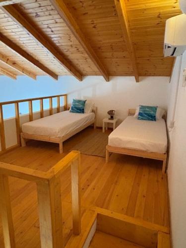 a room with two beds and a wooden floor at Villa Zola with Views in Zóla