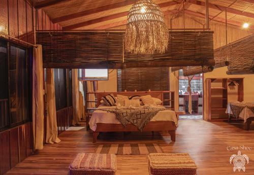 a bedroom with a bed and a chandelier at Casa Shec- An Oceanfront Jungle Retreat in Drake