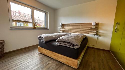 a bed in a room with a window at Ferienwohnung Wiesenweg - Aktiv im Allgäu in Seeg